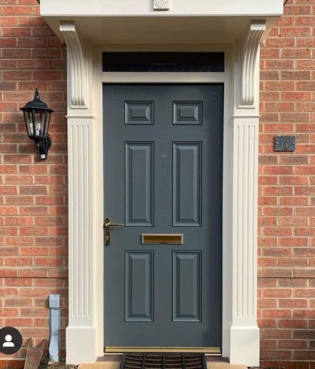 uPVC Door Completion Grey front door with a gold letterbox, flanked by white columns and a wall lantern.