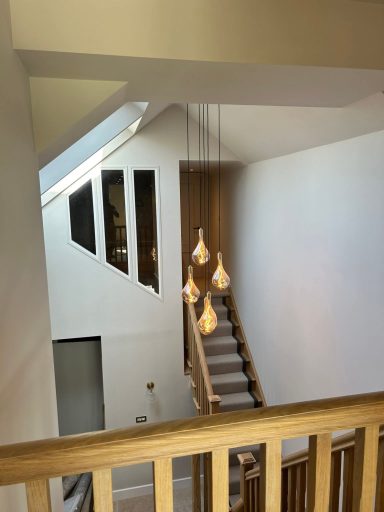 View of a staircase with pendant lights and large windows.
